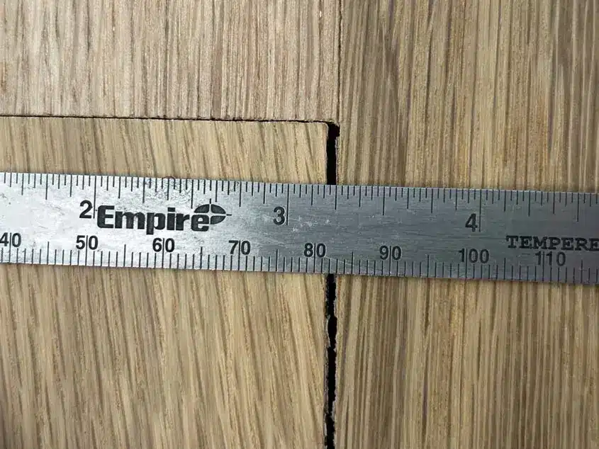 An actual hardwood inspection showing a visible gap between boards