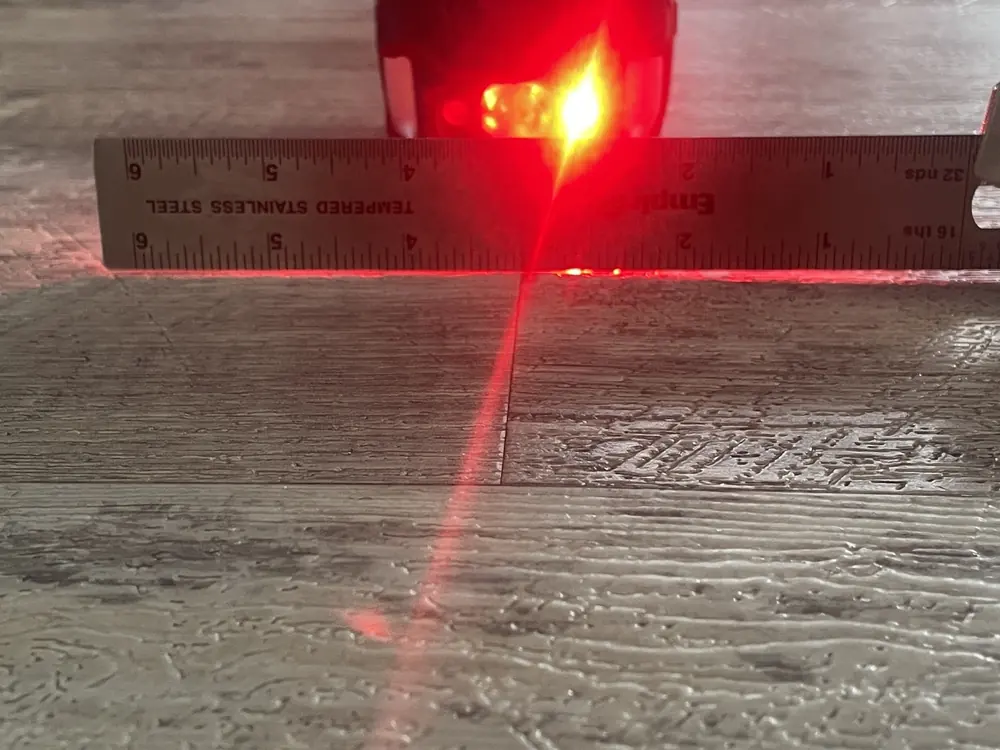 A ruler and backlight help document the shape of the floor surface.