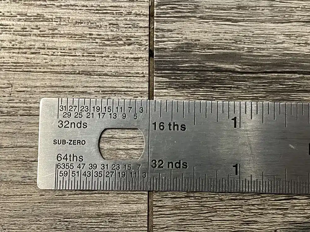 An actual rigid-core flooring inspection showing an open end joint