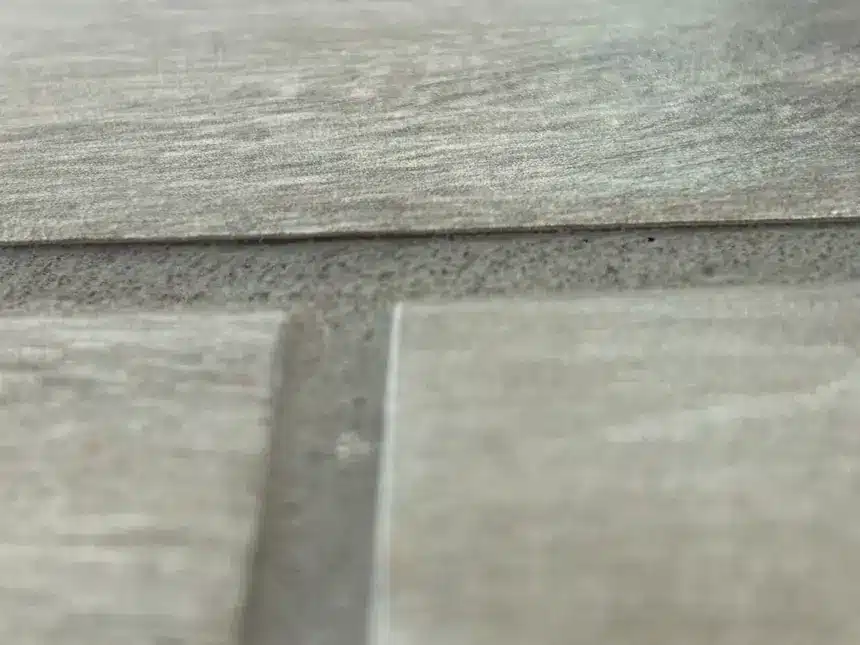 Low grout leaves more of the tile edge exposed in a second inspected installation.